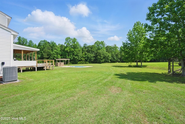 118 Stedman Ln E, Elizabeth City, NC 27909 - view of grassy yard with central air condition unit, an outdoor pool, and view of wooded area