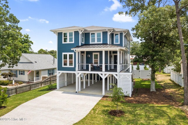 412 Keziah St, Oak Island, NC 28465 - raised beach house with a carport, concrete driveway, covered porch, and a standing seam roof