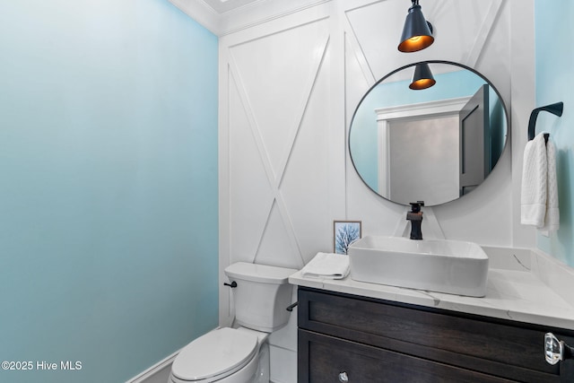 412 Keziah St, Oak Island, NC 28465 - bathroom featuring vanity, toilet, crown molding, and a decorative wall