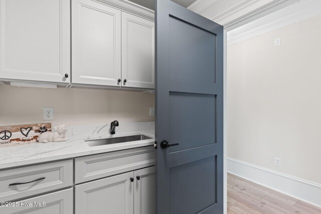 412 Keziah St, Oak Island, NC 28465 - bar area featuring a sink, light wood-style floors, and baseboards