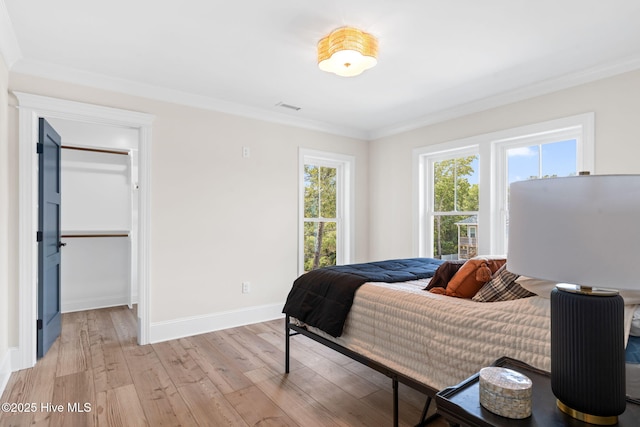 412 Keziah St, Oak Island, NC 28465 - bedroom with ornamental molding, light wood finished floors, baseboards, and a walk in closet