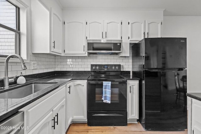 1503 Carolina Beach Ave N Unit 2A, Carolina Beach, NC 28428 - kitchen with black appliances, a sink, white cabinets, tasteful backsplash, and ornamental molding