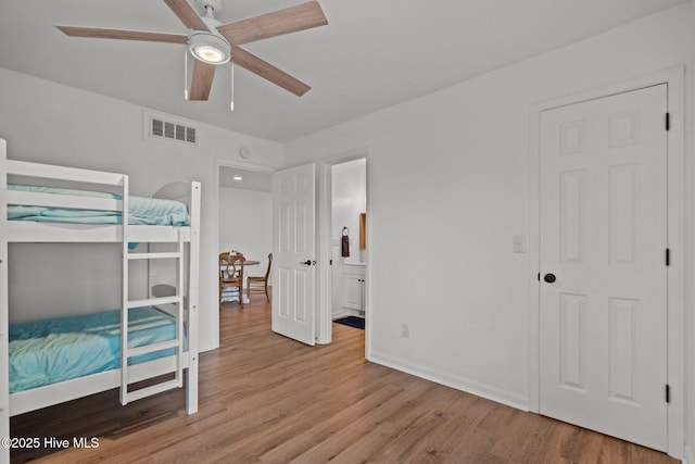 1503 Carolina Beach Ave N Unit 2A, Carolina Beach, NC 28428 - bedroom featuring light wood-style floors, baseboards, connected bathroom, and ceiling fan