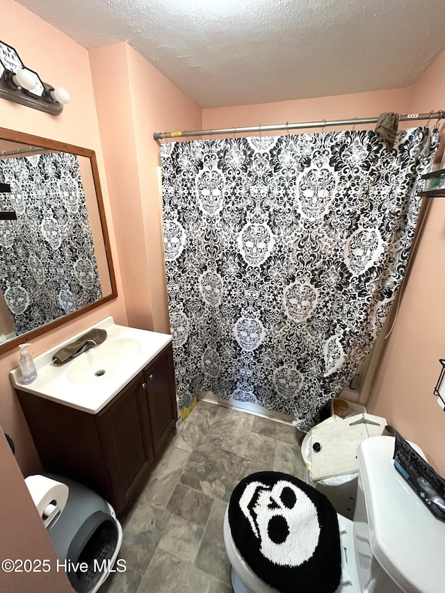1412 Lyon Landing Rd, Elizabethtown, NC 28337 - bathroom featuring toilet, vanity, stone finish flooring, curtained shower, and a textured ceiling