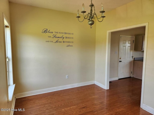 5702 Whichard Rd, Stokes, NC 27884 - unfurnished room with a chandelier, dark wood-style floors, and baseboards