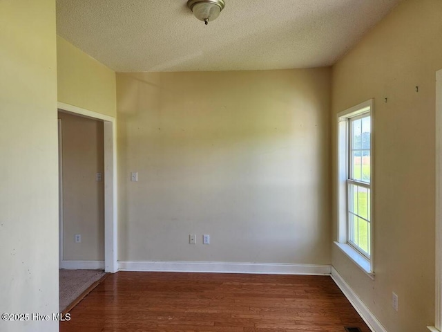 5702 Whichard Rd, Stokes, NC 27884 - empty room with dark wood-type flooring, plenty of natural light, a textured ceiling, and baseboards