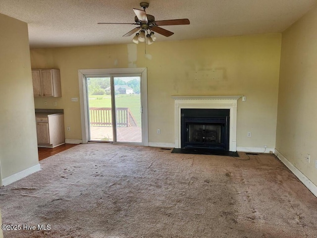 5702 Whichard Rd, Stokes, NC 27884 - unfurnished living room featuring carpet, ceiling fan, a fireplace with flush hearth, baseboards, and a textured ceiling
