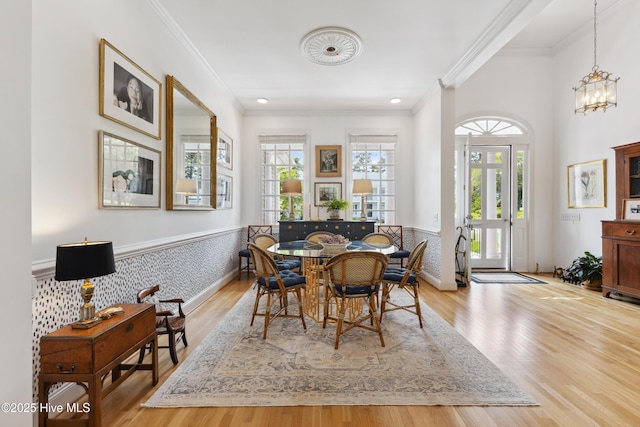 8300 Fazio Dr, Wilmington, NC 28411 - dining area featuring plenty of natural light, crown molding, a chandelier, wood finished floors, and a wainscoted wall