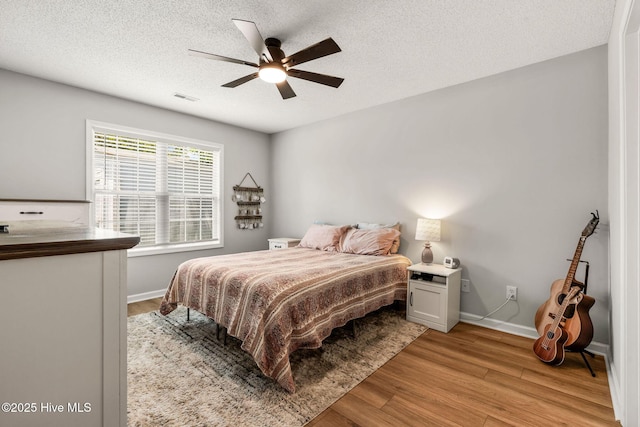 7321 Haskell Ct, Wilmington, NC 28411 - bedroom featuring light wood finished floors, baseboards, ceiling fan, and a textured ceiling