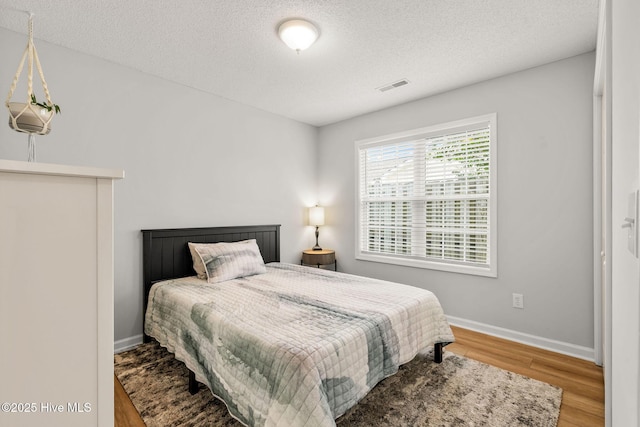 7321 Haskell Ct, Wilmington, NC 28411 - bedroom featuring wood finished floors, a textured ceiling, and baseboards