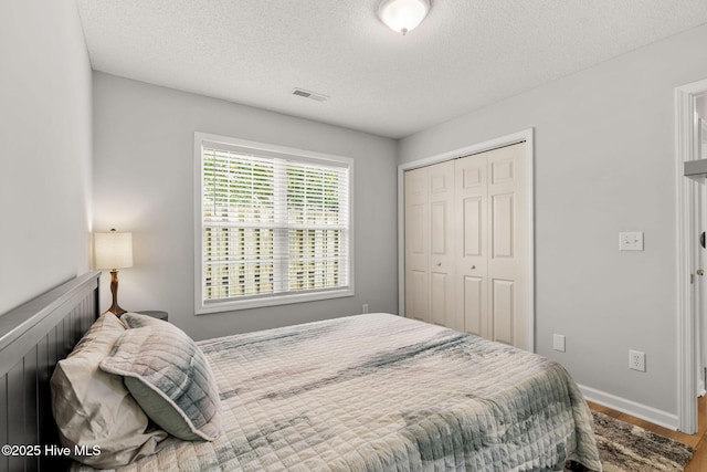 7321 Haskell Ct, Wilmington, NC 28411 - bedroom with a closet, a textured ceiling, wood finished floors, and baseboards