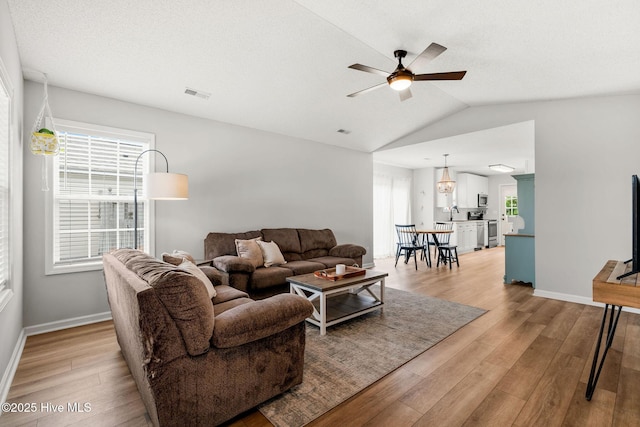 7321 Haskell Ct, Wilmington, NC 28411 - living room featuring ceiling fan, light wood-style flooring, vaulted ceiling, plenty of natural light, and baseboards