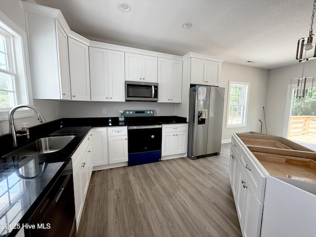 158 Texas Rd, Shiloh, NC 27974 - kitchen featuring appliances with stainless steel finishes, a sink, light wood finished floors, white cabinets, and a textured ceiling