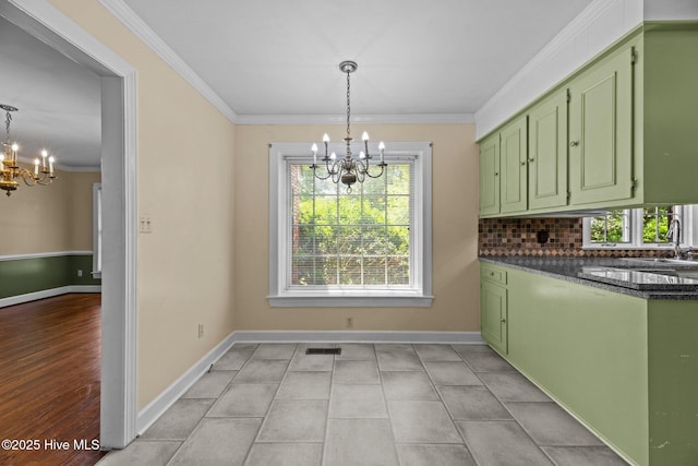 1510 Lucerne Way, New Bern, NC 28560 - unfurnished dining area featuring a chandelier, crown molding, baseboards, and a sink