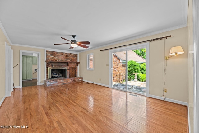 1510 Lucerne Way, New Bern, NC 28560 - unfurnished living room featuring a ceiling fan, crown molding, light wood-type flooring, baseboards, and a brick fireplace