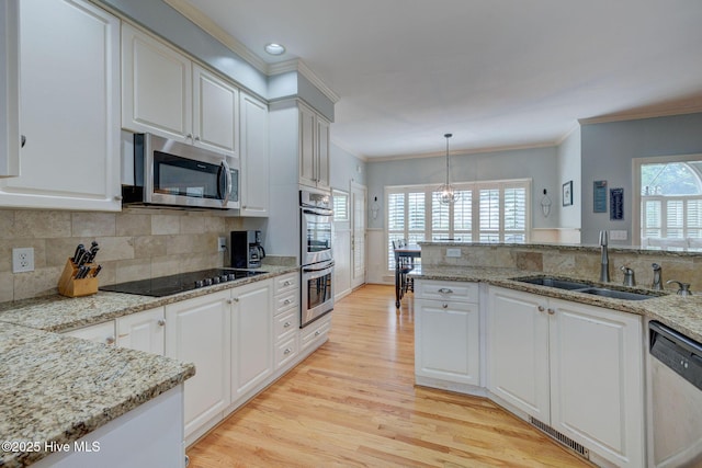 809 Berwyn Rd, Wilmington, NC 28409 - kitchen with stainless steel appliances, a sink, light wood-style floors, ornamental molding, and white cabinetry