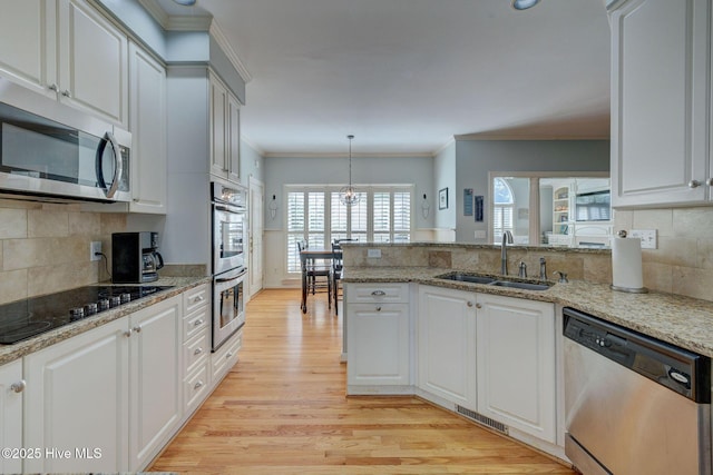 809 Berwyn Rd, Wilmington, NC 28409 - kitchen featuring stainless steel appliances, a sink, backsplash, ornamental molding, and white cabinetry