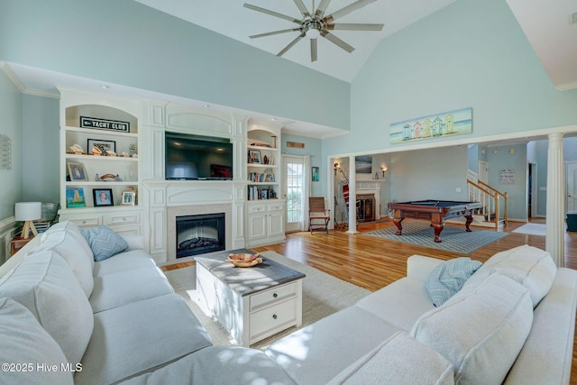 809 Berwyn Rd, Wilmington, NC 28409 - living room with a high end fireplace, ceiling fan, high vaulted ceiling, light wood-type flooring, and built in shelves