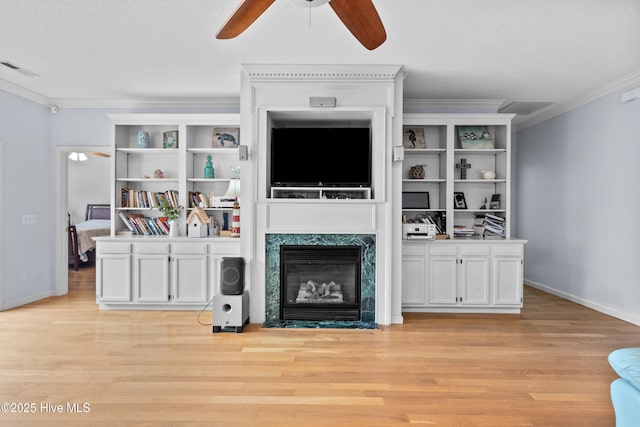 1434 Wagon Ct, Wilmington, NC 28412 - unfurnished living room featuring ceiling fan, light wood-type flooring, crown molding, a premium fireplace, and a textured ceiling