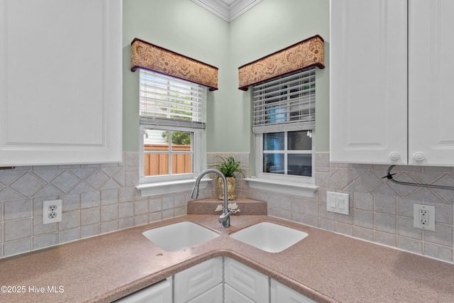 1434 Wagon Ct, Wilmington, NC 28412 - kitchen featuring a sink, white cabinets, ornamental molding, decorative backsplash, and light countertops