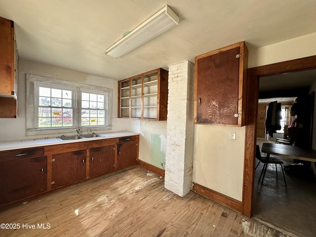 718 Beasley Rd, Roper, NC 27970 - kitchen with a sink, baseboards, light countertops, light wood finished floors, and glass insert cabinets