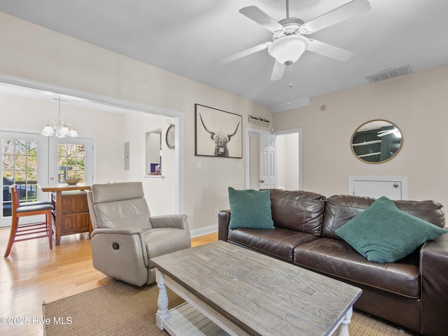 98 Mccain Ln Unit 3, Swansboro, NC 28584 - living room featuring light wood-style flooring, a chandelier, ceiling fan, baseboards, and electric panel