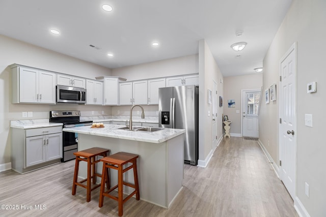 210 N Stingray Ln, Sneads Ferry, NC 28460 - kitchen featuring appliances with stainless steel finishes, a sink, light wood finished floors, a center island with sink, and recessed lighting