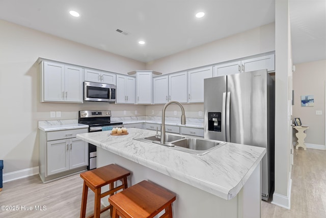 210 N Stingray Ln, Sneads Ferry, NC 28460 - kitchen featuring appliances with stainless steel finishes, a sink, baseboards, light wood-style floors, and recessed lighting