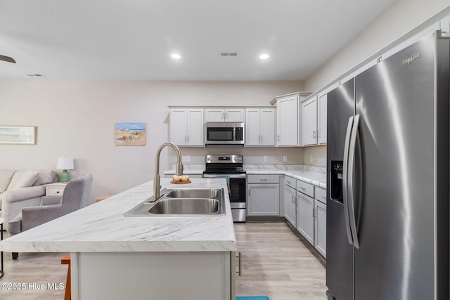 210 N Stingray Ln, Sneads Ferry, NC 28460 - kitchen with stainless steel appliances, a sink, light wood finished floors, light countertops, and recessed lighting