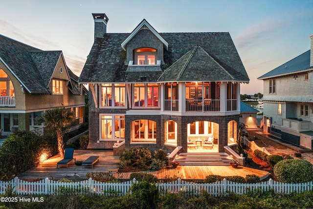 218 Row Boat Row, Bald Head Island, NC 28461 - rear view of house with a fenced front yard, a chimney, a patio area, and a wooden deck