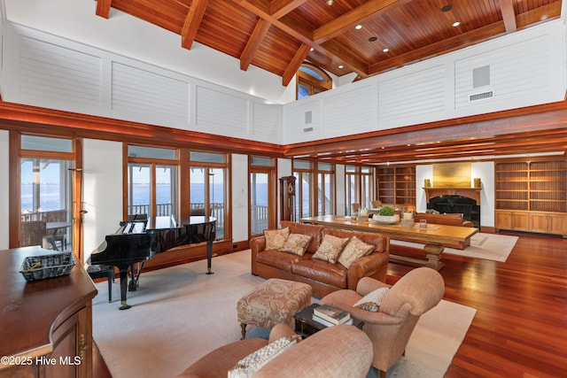 218 Row Boat Row, Bald Head Island, NC 28461 - living room featuring wood ceiling with exposed beams, a fireplace, a towering ceiling, and wood finished floors