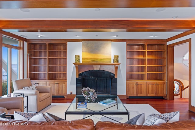 218 Row Boat Row, Bald Head Island, NC 28461 - living area featuring wood finished floors, a high end fireplace, beamed ceiling, and built in shelves