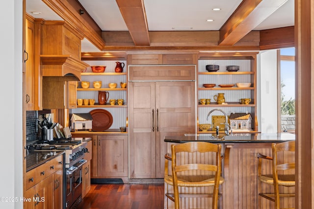 218 Row Boat Row, Bald Head Island, NC 28461 - kitchen featuring open shelves, range with two ovens, beam ceiling, dark wood finished floors, and a kitchen bar