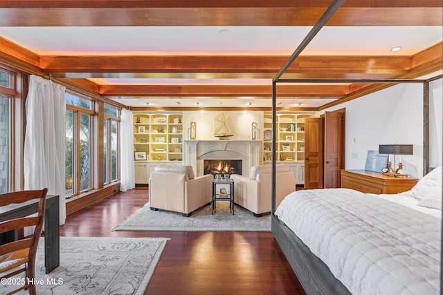 218 Row Boat Row, Bald Head Island, NC 28461 - bedroom featuring dark wood-type flooring, a warm lit fireplace, and beamed ceiling
