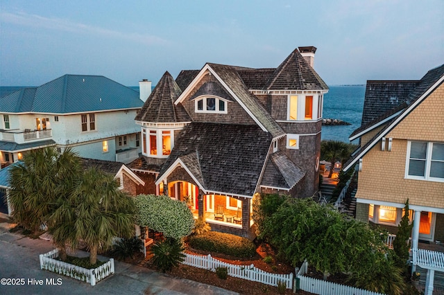 218 Row Boat Row, Bald Head Island, NC 28461 - shingle-style home featuring a chimney, a fenced front yard, and a water view