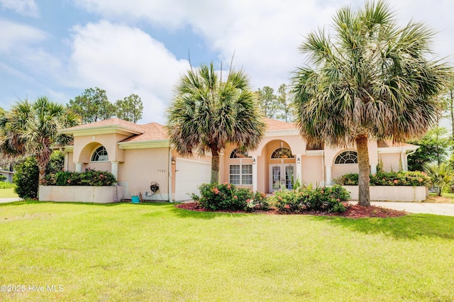 7120 Orchard Trce, Wilmington, NC 28409 - mediterranean / spanish-style home with french doors, a front yard, stucco siding, and a garage