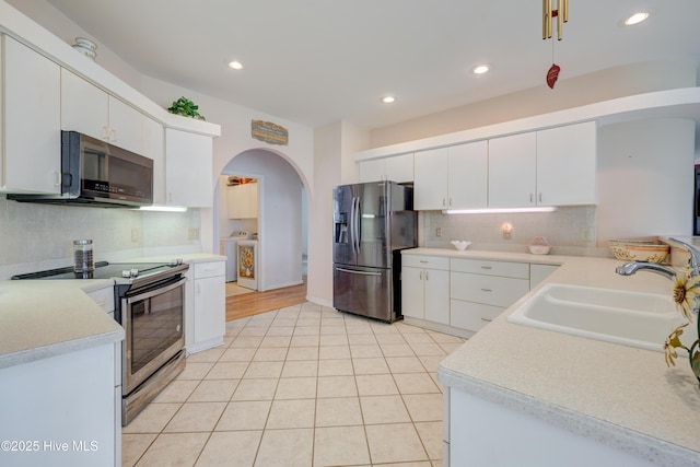 7120 Orchard Trce, Wilmington, NC 28409 - kitchen featuring stainless steel appliances, washing machine and dryer, a sink, arched walkways, and recessed lighting