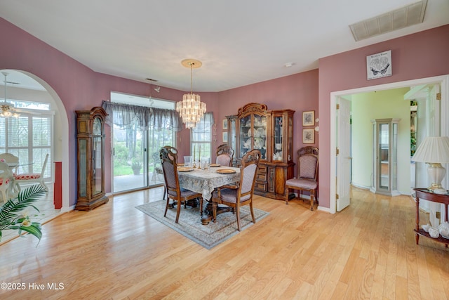 7120 Orchard Trce, Wilmington, NC 28409 - dining area featuring a chandelier, light wood finished floors, baseboards, and arched walkways