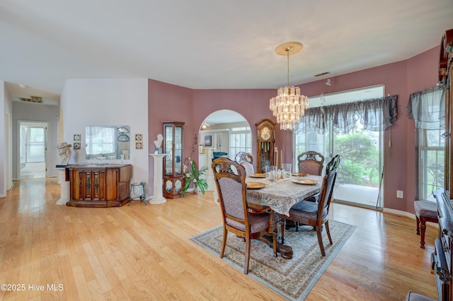 7120 Orchard Trce, Wilmington, NC 28409 - dining space featuring arched walkways, a chandelier, light wood-style flooring, and baseboards