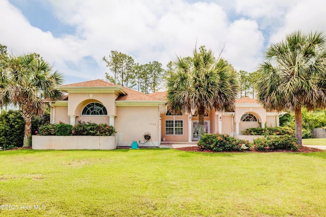 7120 Orchard Trce, Wilmington, NC 28409 - mediterranean / spanish home featuring a front lawn and stucco siding