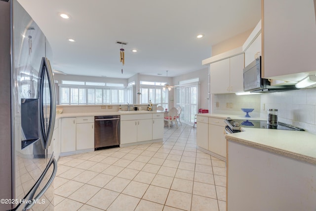 7120 Orchard Trce, Wilmington, NC 28409 - kitchen with appliances with stainless steel finishes, light countertops, light tile patterned flooring, recessed lighting, and white cabinetry