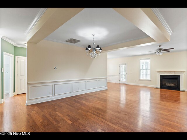 822 Lambrook Dr, Wilmington, NC 28411 - unfurnished living room featuring a chandelier, crown molding, ceiling fan, a glass covered fireplace, and wood finished floors