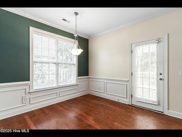 822 Lambrook Dr, Wilmington, NC 28411 - unfurnished dining area featuring plenty of natural light, dark wood-style flooring, ornamental molding, and a wainscoted wall