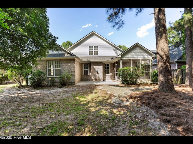 822 Lambrook Dr, Wilmington, NC 28411 - rear view of house featuring a sunroom, a patio area, and brick siding