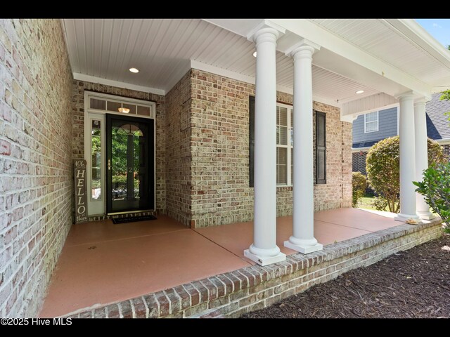 822 Lambrook Dr, Wilmington, NC 28411 - doorway to property featuring covered porch and brick siding