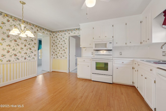 3007 Camelot Dr, Kinston, NC 28504 - kitchen with white appliances, a sink, a chandelier, white cabinets, and wallpapered walls
