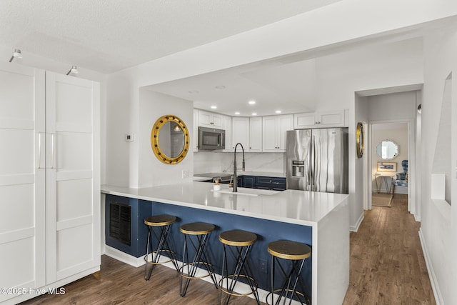 2106 E Fort Macon Rd Unit 310Tar, Atlantic Beach, NC 28512 - kitchen featuring appliances with stainless steel finishes, dark wood-style flooring, a kitchen bar, a peninsula, and recessed lighting