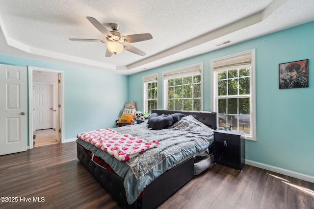 218 Yearling Loop, Jacksonville, NC 28540 - bedroom featuring a tray ceiling, baseboards, dark wood-style floors, and a textured ceiling