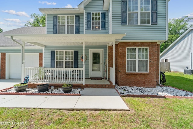 218 Yearling Loop, Jacksonville, NC 28540 - view of front of property with covered porch, an attached garage, brick siding, and a front yard