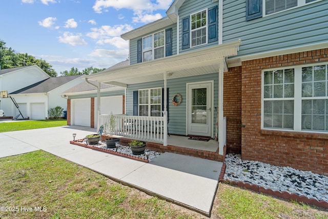 218 Yearling Loop, Jacksonville, NC 28540 - view of front facade featuring covered porch, concrete driveway, an attached garage, and brick siding